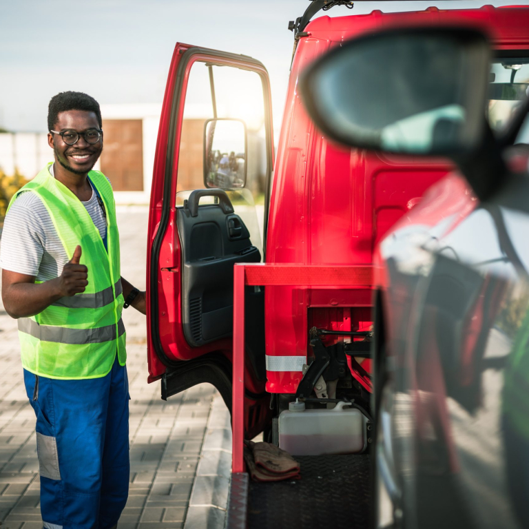 Young handsome African American man working in towing service and driving his truck.